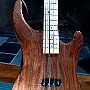 Short scale (30") bass with one single-coil pickup.  Through-body neck design.  Body core of white cedar with figured black walnut top and back veneers.  Maple neck and fingerboard.  